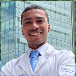 Person wearing a white coat in front of a building