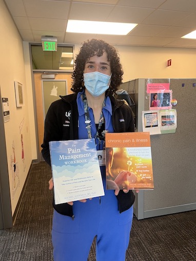 Masked doctor holding neurology books for children