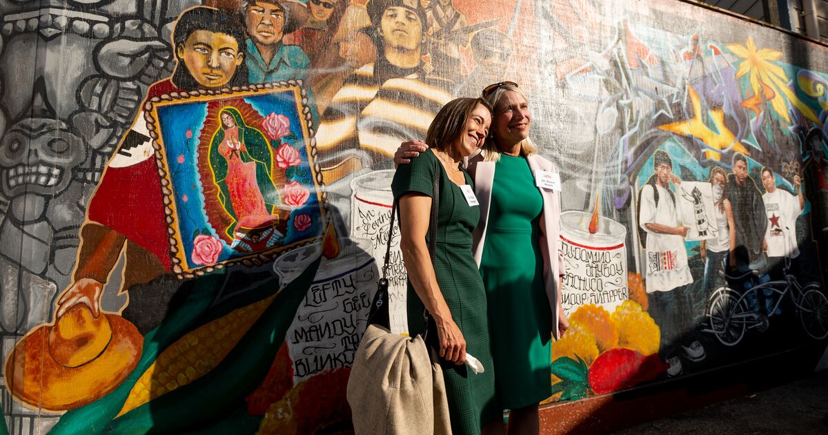 two women in front of a painted wall in SF's Mission District