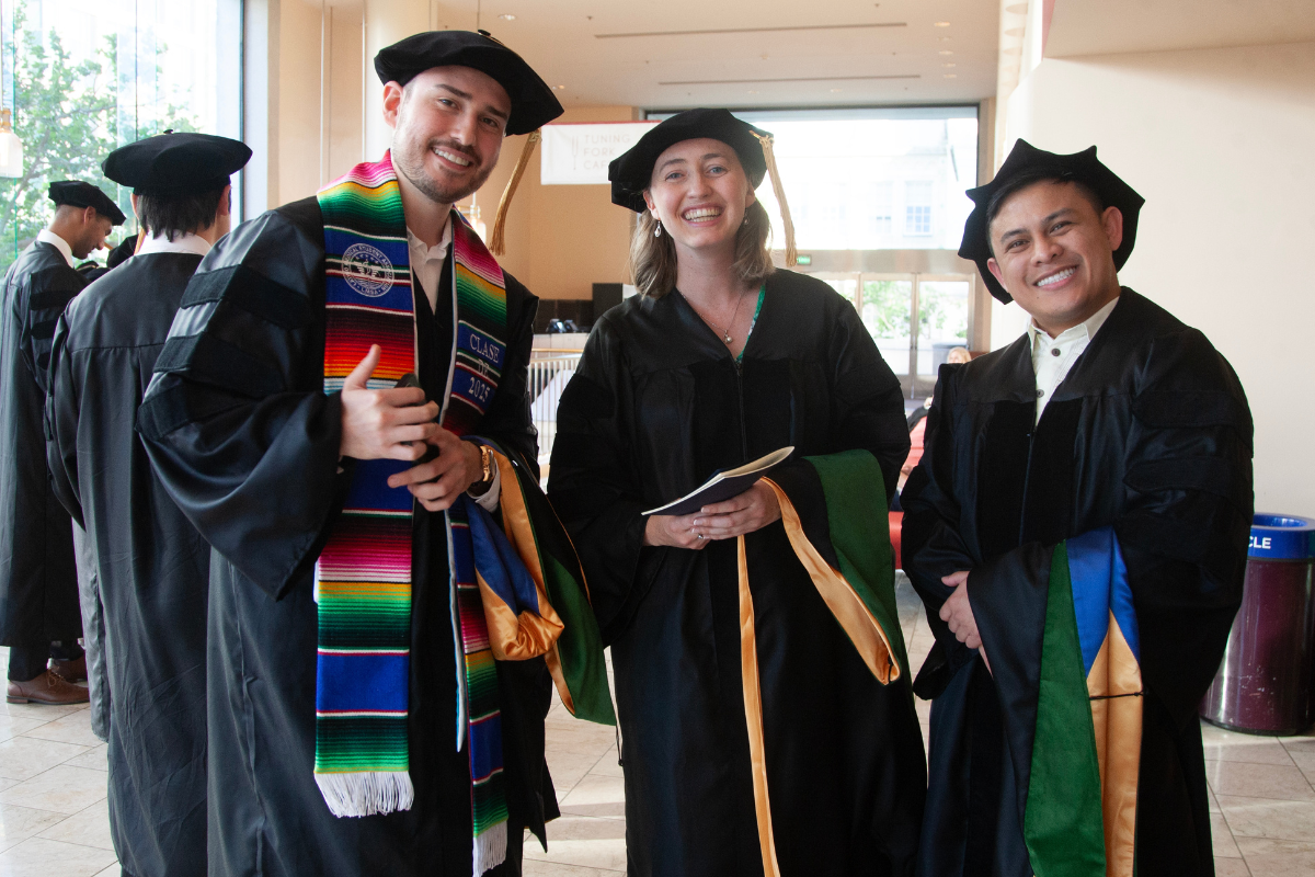 Students at graduation hugging and smiling