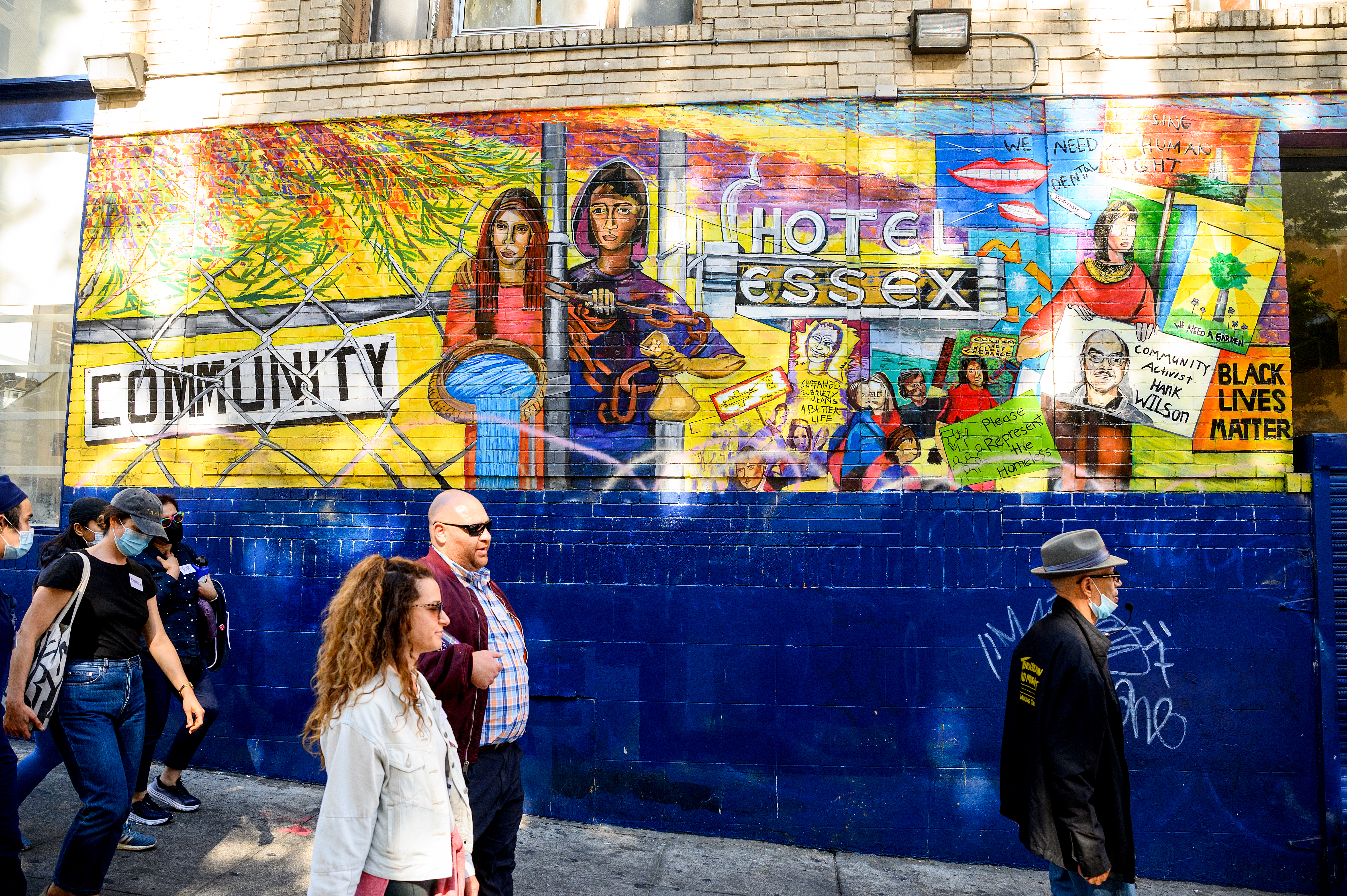 people walking by a colorfully painted wall outside Glide Memorial church