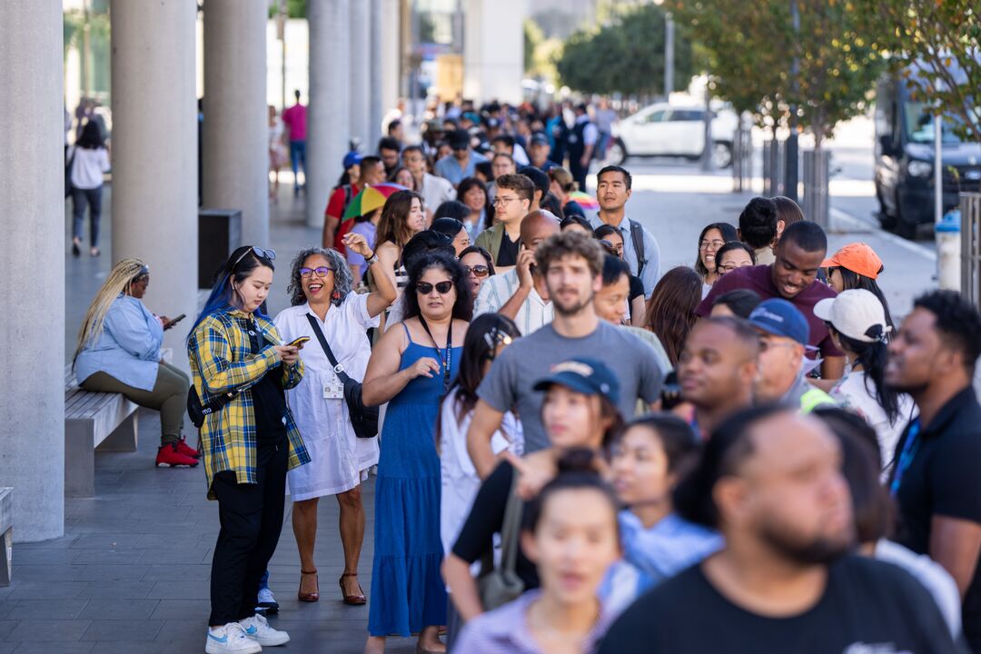 people smiling waiting in a line outside