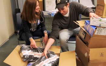 Katie Machado (left) and Henry Carter (right), co-directors of the Clinic Leadership Board, prepare supplies for the Shelter Clinic's Health Fair in June 2019.