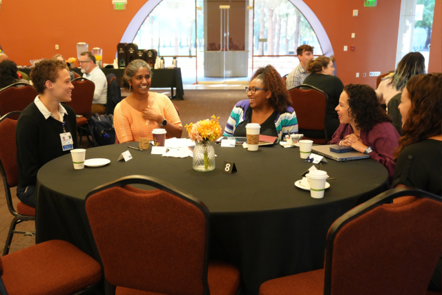 People seated at a conference table in conversation