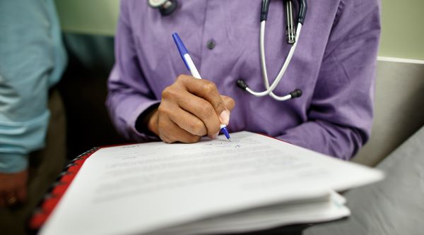 Physician writing with a pen