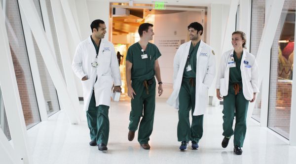 doctors walking in the hallway while having a conversation and smiling 