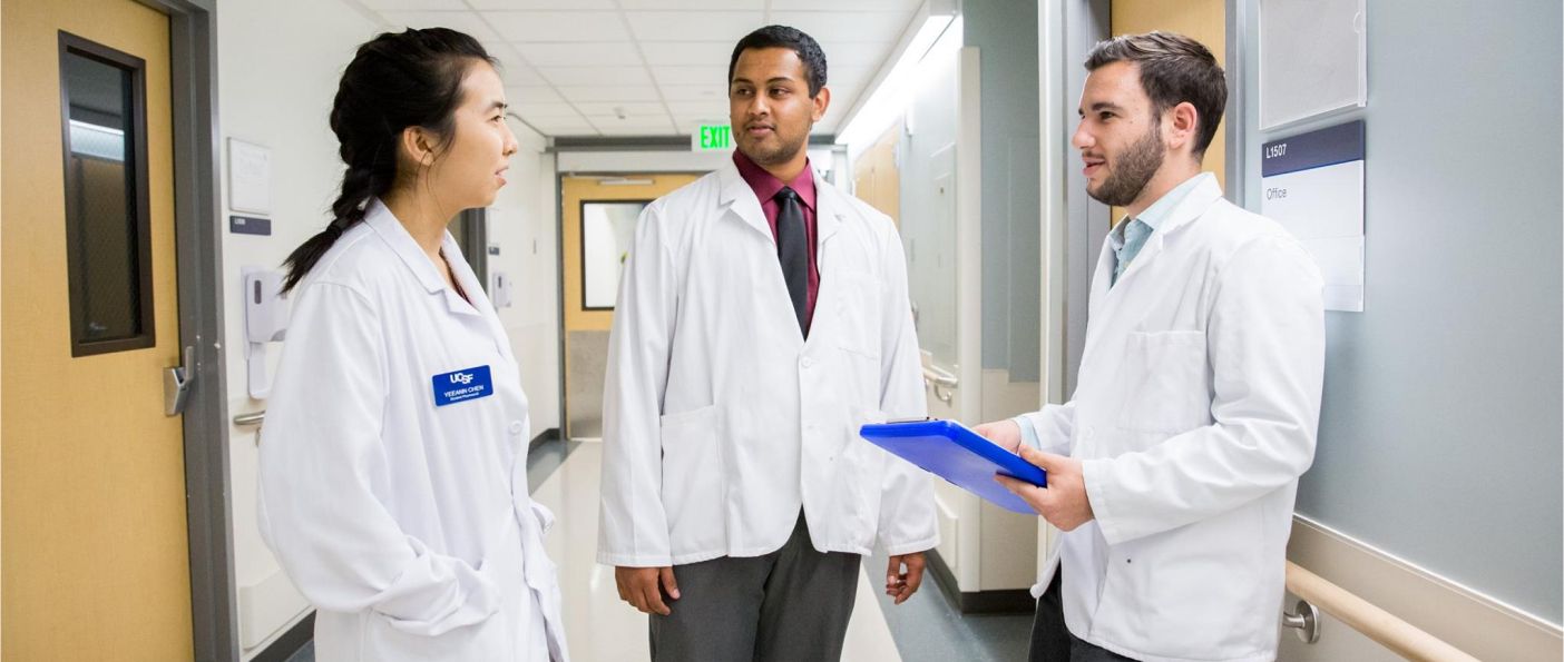 Three doctors discussing in a hospital hallway